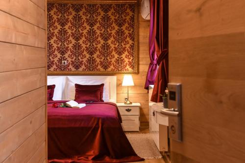 a bedroom with a bed with purple sheets and a curtain at Lakeside Hotel Plitvice in Plitvička Jezera