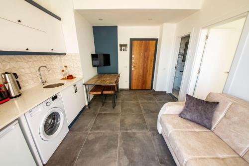 a kitchen and a living room with a couch at Granda Lambuka Apart in Kas