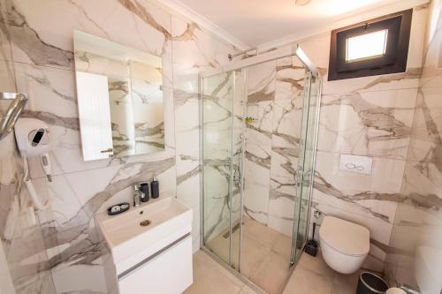 a bathroom with a shower and a toilet at Granda Lambuka Apart in Kas