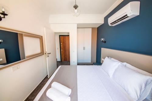 a bedroom with a white bed and a blue wall at Granda Lambuka Apart in Kas