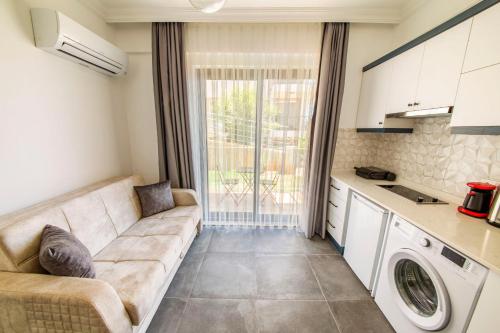 a living room with a couch and a kitchen at Granda Lambuka Apart in Kas