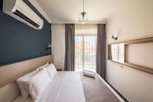a bedroom with a white bed with a window at Granda Lambuka Apart in Kas