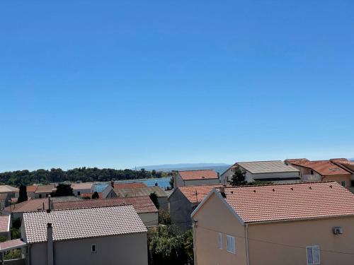 a view of a city with houses and the ocean at Apartments Toma in Novalja