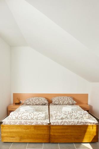 a bed with a wooden frame in a bedroom at Sakota family house in Sremska Kamenica