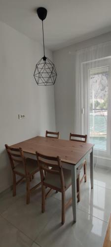 a dining room table with two chairs and a light fixture at Barakokula in Omiš