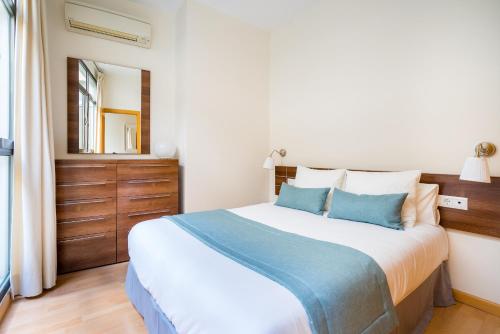 a bedroom with a large bed and a mirror at HOMEABOUT FRESCA Apartment II in Málaga