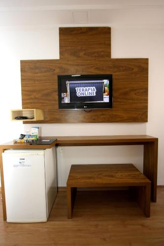 a kitchen with a counter with a tv on a wall at Laguna Plaza Hotel in Brasilia