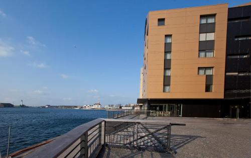 a building next to a large body of water at All Suites Appart Hôtel - Dunkerque Centre in Dunkerque