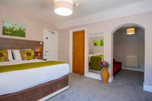 a bedroom with a large bed and a red couch at The Limes Country Lodge Hotel & Admiral Restaurant in Solihull