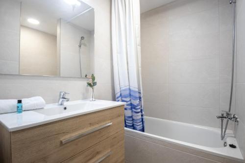 a bathroom with a sink and a tub and a shower at Bonito estudio renovado in Salou
