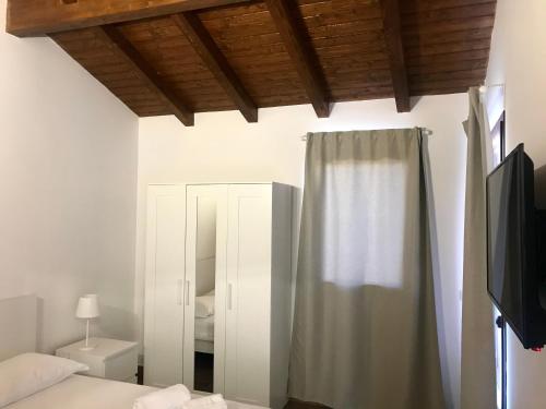 1 dormitorio con cama, espejo y cortina en Agricampeggio Verde Etna en Aci SantʼAntonio