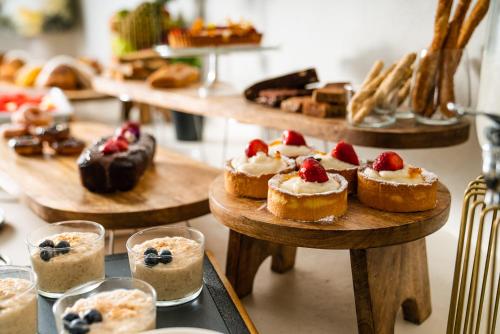 a bunch of pastries and desserts on wooden plates at Koukoumi Vegan Boutique Hotel in Ano Mera