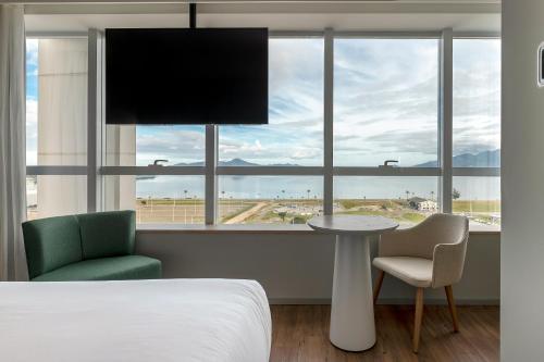 Un dormitorio con una cama y una mesa y una ventana. en K-Platz Hotel, en São José
