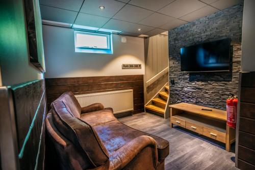a living room with a leather chair and a tv at Eriks Villa in Funäsdalen