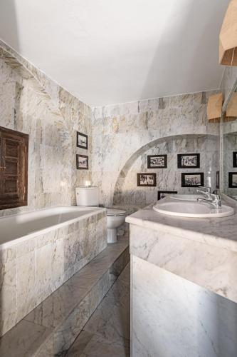 a bathroom with a tub and a sink and a toilet at Eole Tarifa Rooms in Tarifa