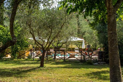 a fence with a picnic table in a park with trees at Agriturismo La Fonte in Bevagna