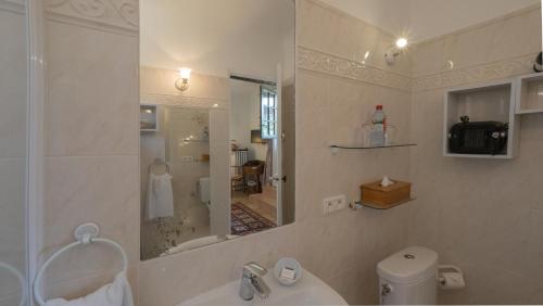 a bathroom with a sink and a toilet and a mirror at Hotel-Restaurant Le Moulin De La Camandoule in Fayence