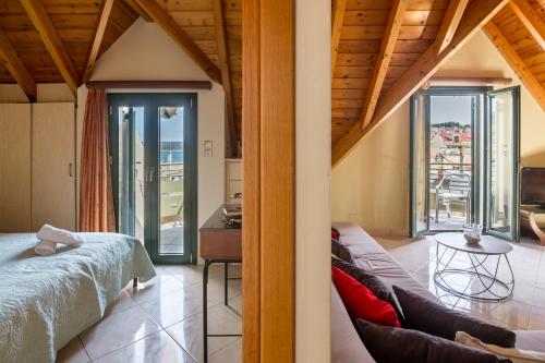 a bedroom with a bed and a couch and a table at Una Bella Mansarda in Argostoli