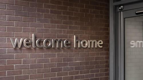 a welcome home sign on a brick wall at Staybridge Suites Newcastle by IHG in Newcastle upon Tyne