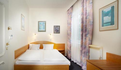 a bedroom with a white bed and a window at Pension Kern in Prague