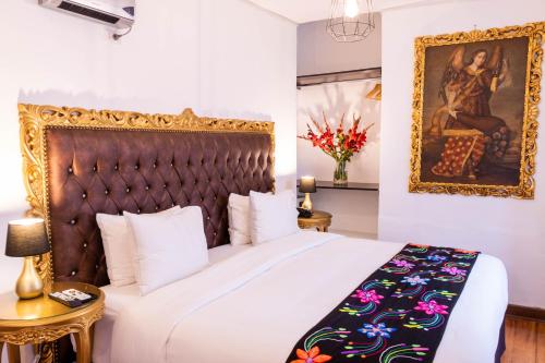 a bedroom with a bed and a painting on the wall at Auka Boutique San Blas in Cusco