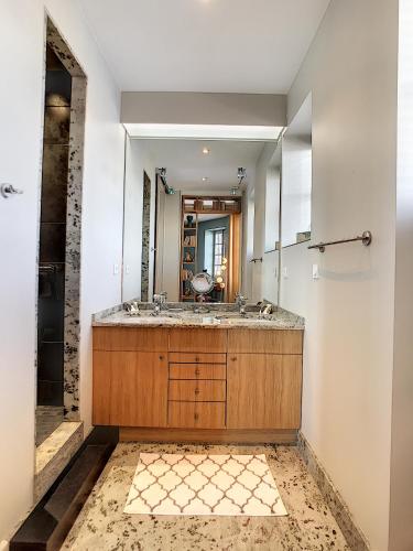 une salle de bain avec un lavabo et un miroir dans l'établissement Les Cimes du Puy-en-Velay, au Puy-en-Velay