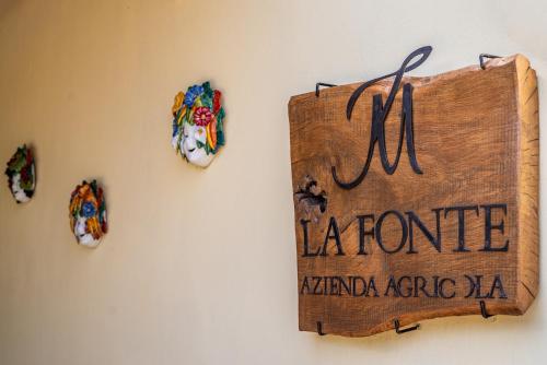a wooden sign on a wall with some magnets at Agriturismo La Fonte in Bevagna