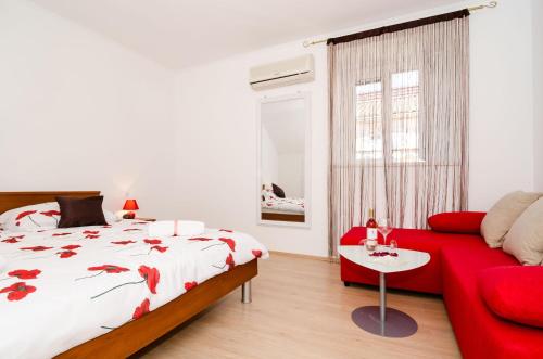 1 dormitorio con cama roja y sofá rojo en Apartment Ira, en Dubrovnik