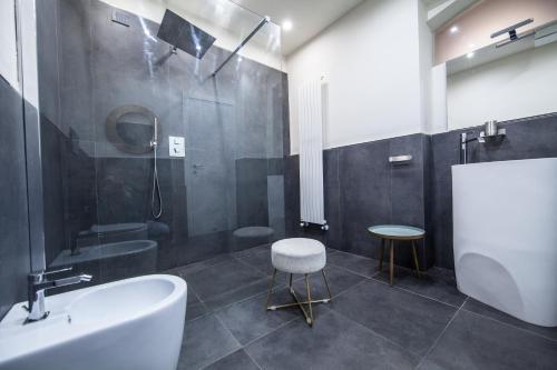 uma casa de banho com uma banheira, um lavatório e um banco em Historic Center Luxury Apartment em Lucca