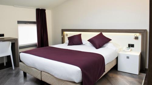 a bedroom with a large bed with purple pillows at Hotel Corte Del Paggio in Valeggio sul Mincio