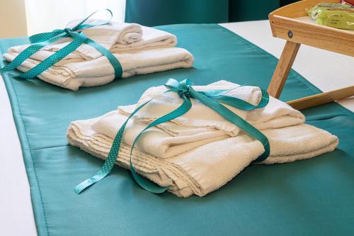 three folded towels are tied up on a bed at Re Diego in Naples