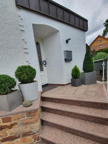 Casa blanca con escaleras que conducen a la puerta principal en Pension Backhaus, en Waldeck