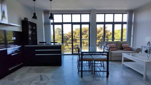 eine Küche und ein Wohnzimmer mit einem Tisch und Stühlen in der Unterkunft APARTAMENTOS MINA4 tipo I in Cádiz