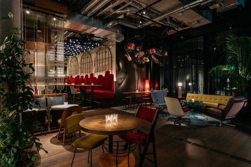 a restaurant with tables and chairs in a room at Ruby Ella Hotel Cologne in Cologne