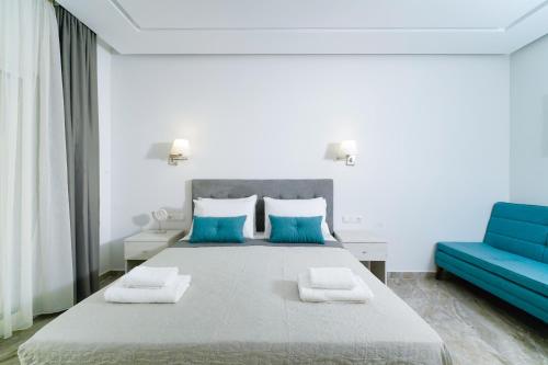 a bedroom with a large bed and a blue couch at Tarsa's House by the Sea in Skala Marion