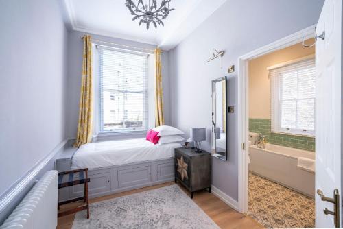 a bedroom with a bed and a bath tub next to a window at Eight in Bath