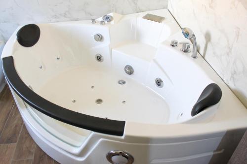 een wit bad in een badkamer met een marmeren muur bij Thalasso Rooms B&B in Cirella