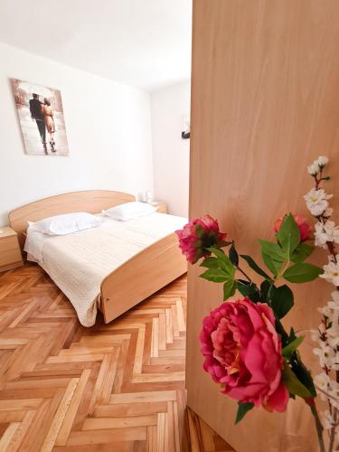 a bedroom with a bed and a vase with flowers at Holiday home Srdašce in Perković