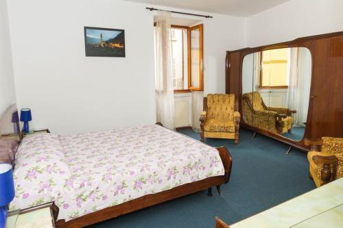 a bedroom with a bed and two chairs in it at House of cats in Domaso