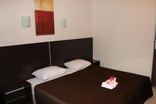 a bedroom with a black bed with two white pillows at Solar Apartments in Herceg-Novi