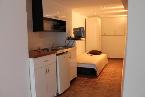 a small kitchen with a bed and a sink at Solar Apartments in Herceg-Novi