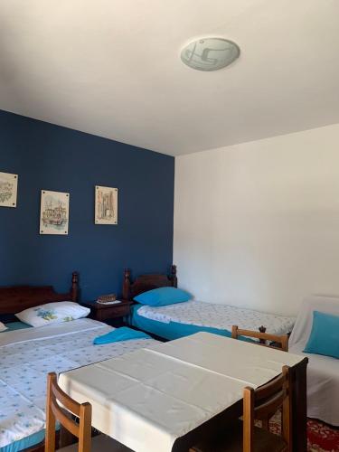 a room with two beds and a blue wall at Studio apartman in Meljine
