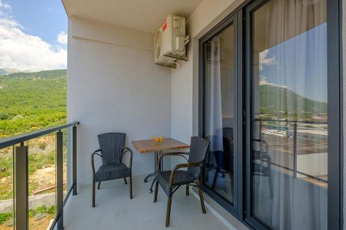 a balcony with a table and chairs and a view at Dubrave apartmani in Budva