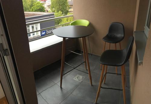 a small table and two chairs in front of a window at Apartman CITY CENTER 3-šetalište in Prijedor