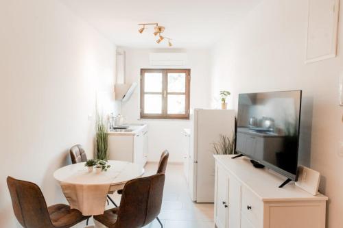 a kitchen with a table and chairs and a refrigerator at Kuća u centru in Pakoštane