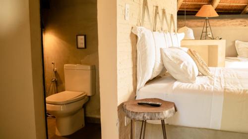 a bedroom with a white bed and a toilet at Tava Cerro in San Bernardino