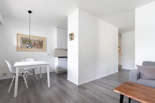 a white living room with a table and a couch at Riverside Apartment Rovaniemi in Rovaniemi