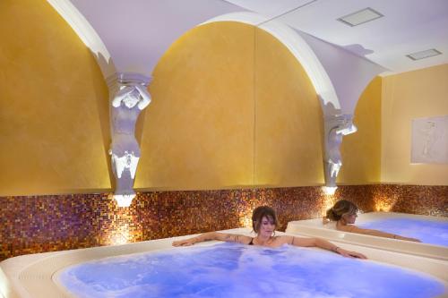 two women in hot tubs in a bathroom at Saint George's House Appartamenti & Spa in Pachino