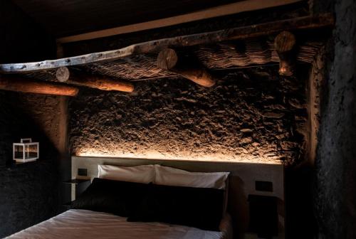 1 dormitorio con 1 cama con techo de madera en Lou Estela - L'essiccatoio, en Moiola