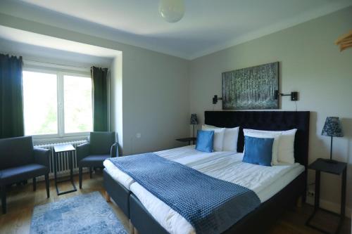 a bedroom with a large bed with blue pillows at Park Hotell in Kristinehamn